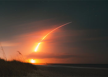 a space launch in the night over the beach