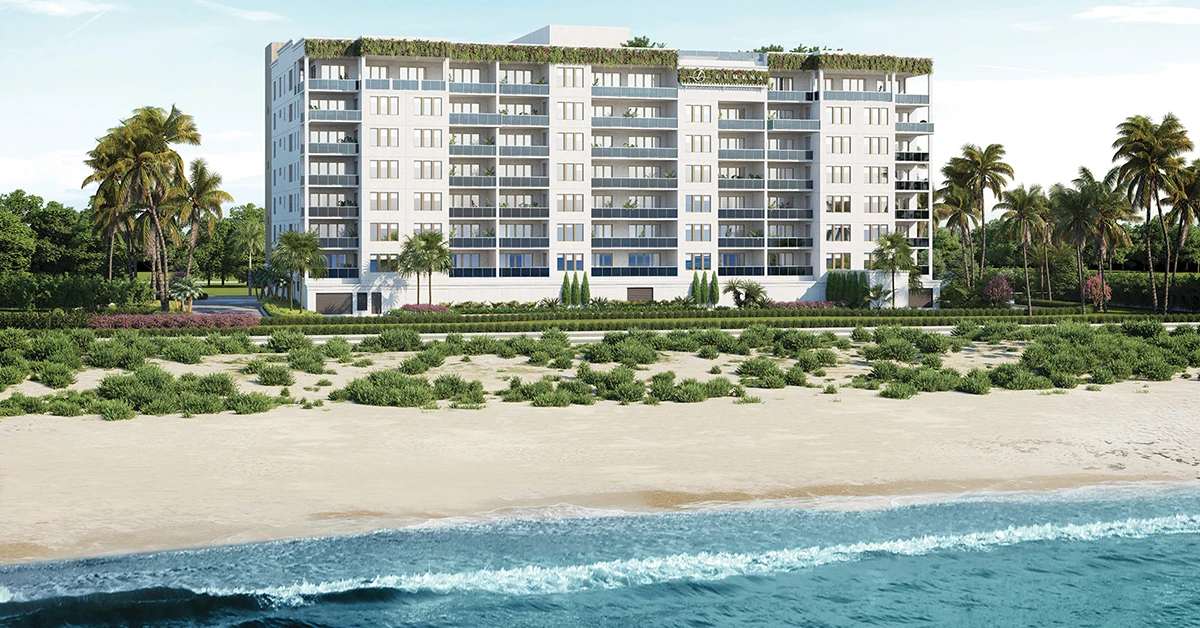 Oceanfront condo building along sandy beach with palm trees